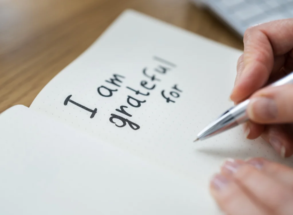 A woman writing a gratitude journal